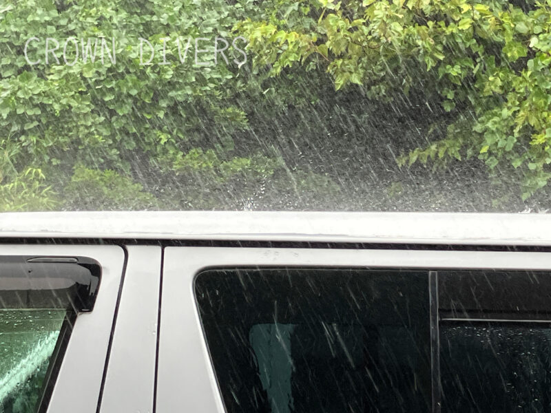 大雨が車の屋根に雨を叩きつけている