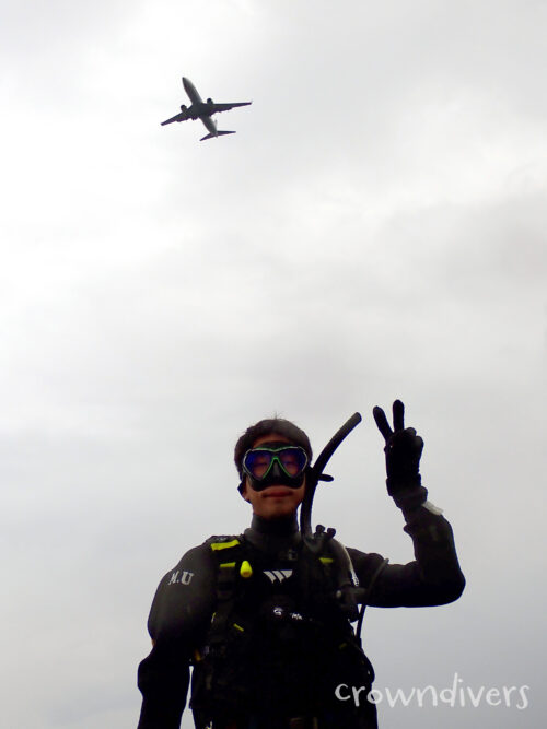 飛行機と一緒に写真に写るダイバー